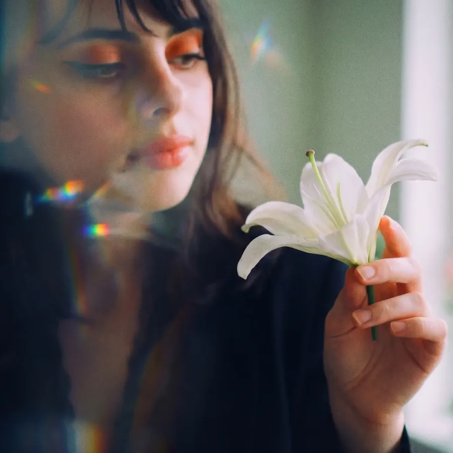 Lily holding a white lily in soft prism light