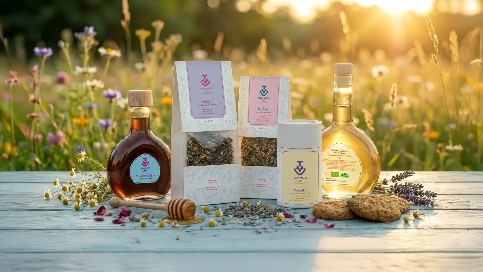 Terra Mater herbal teas and syrups in their new packaging on a table in a summer meadow